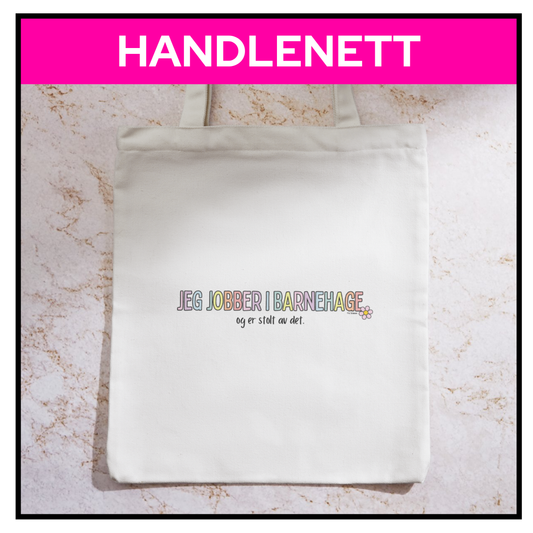 Handlenett med teksten «Jeg jobber i barnehage og er stolt av det» – liggende på bord
