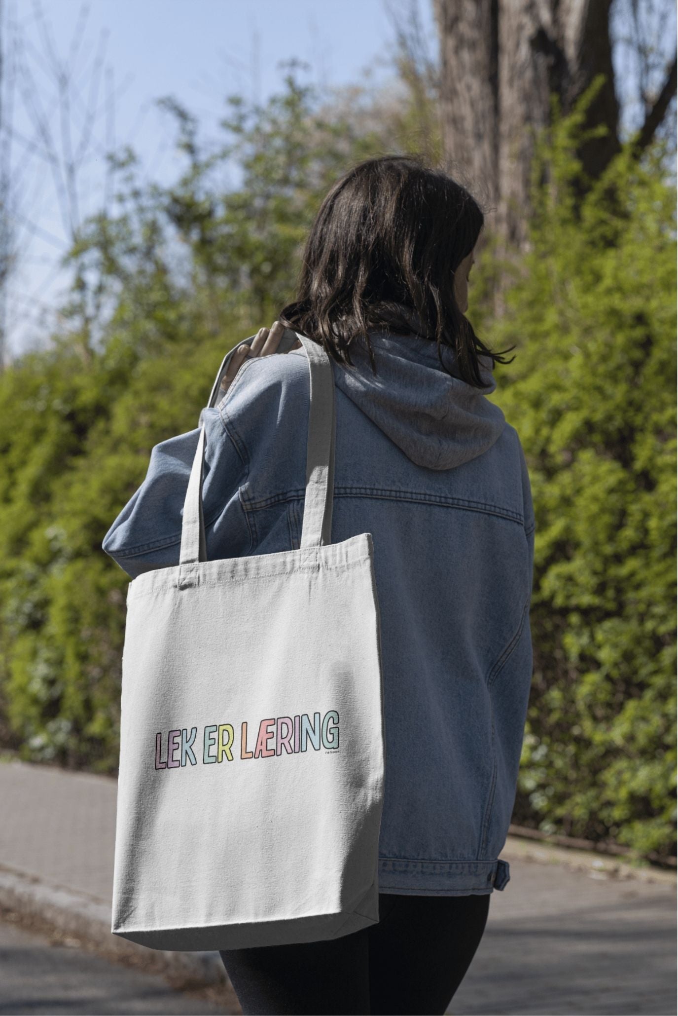 
Person med handlenettet «Lek er læring» over skulderen

